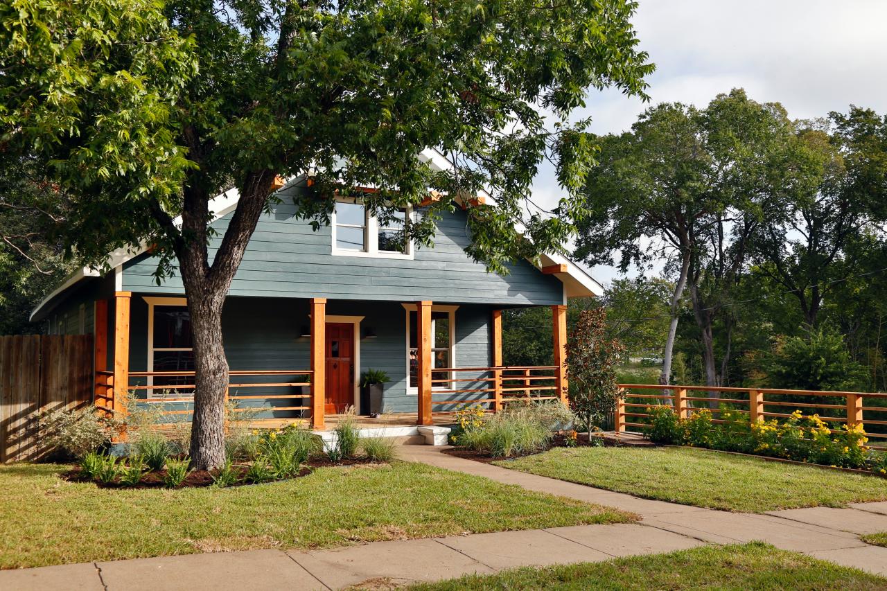 The outside of a newly renovated house with a porch and manicured lawn