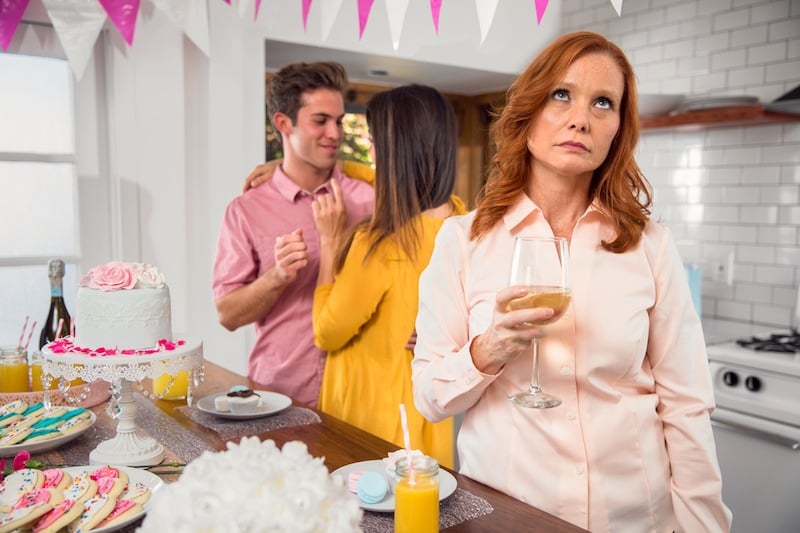 woman rolling eyes at couple at party