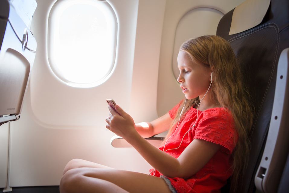 Adorable little girl traveling by an airplane