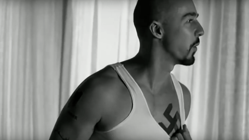 Derek pulls down a white shirt to reveal a swastika tattoo in American History X Derek pulls down a white shirt to reveal a swastika tattoo in American History X