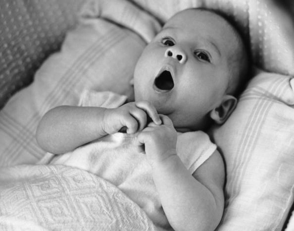 Baby yawns under blankets