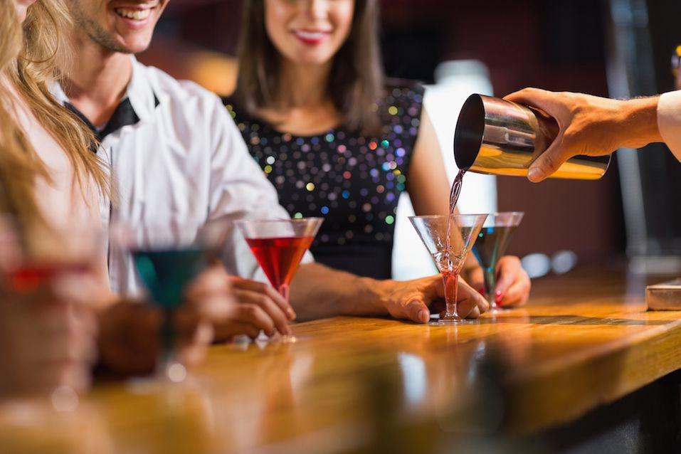 Bartender pouring cocktail for customers