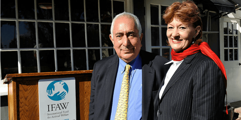 Ben Stein and Alexandra Denman are smiling together in front of a podium. Ben Stein and Alexandra Denman are smiling together in front of a podium.