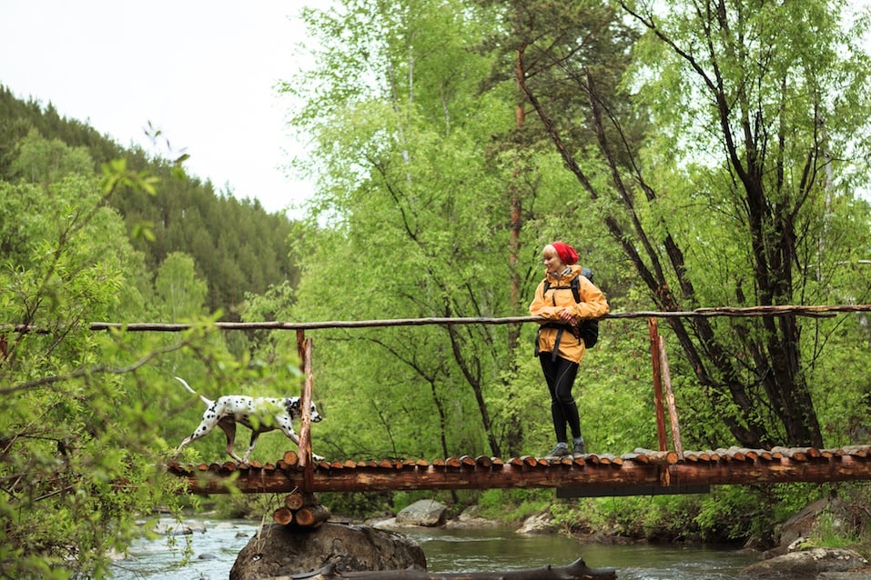 Blond girl walking with her dog on the bridge