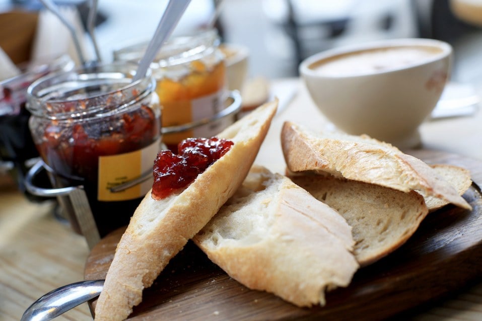 Breakfast, three jars of jam and sliced bread