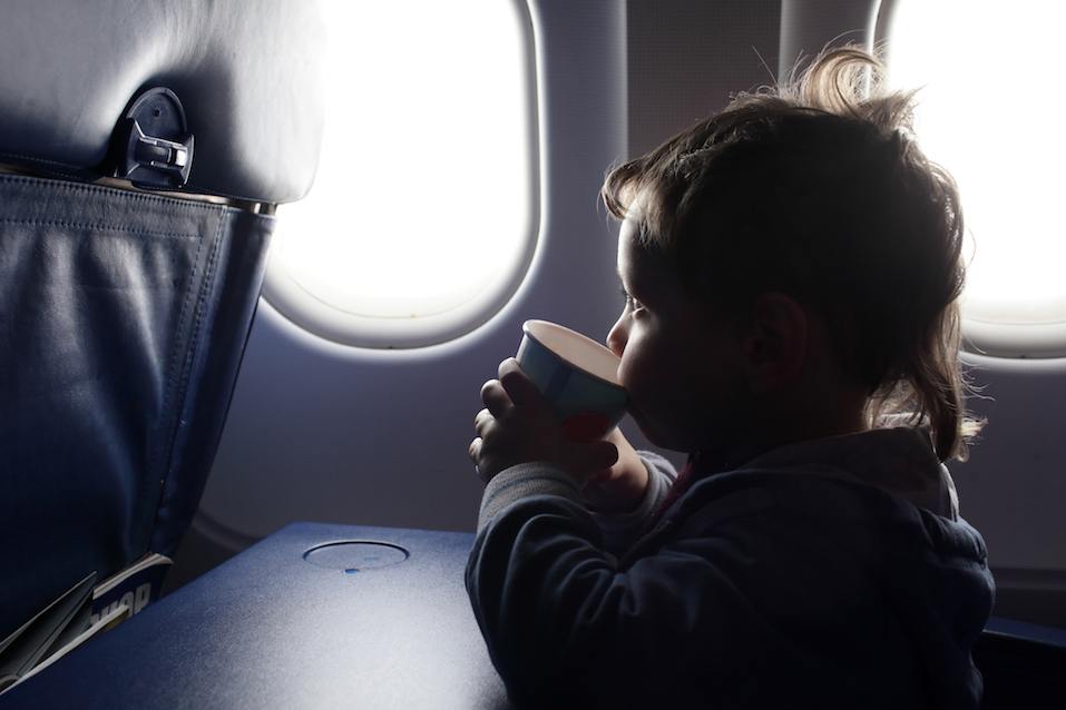The child drinks tea in the airplane