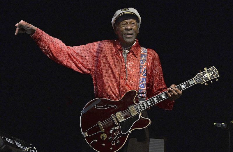 Chuck Berry holds a guitar and sings at a concert in 2013.
