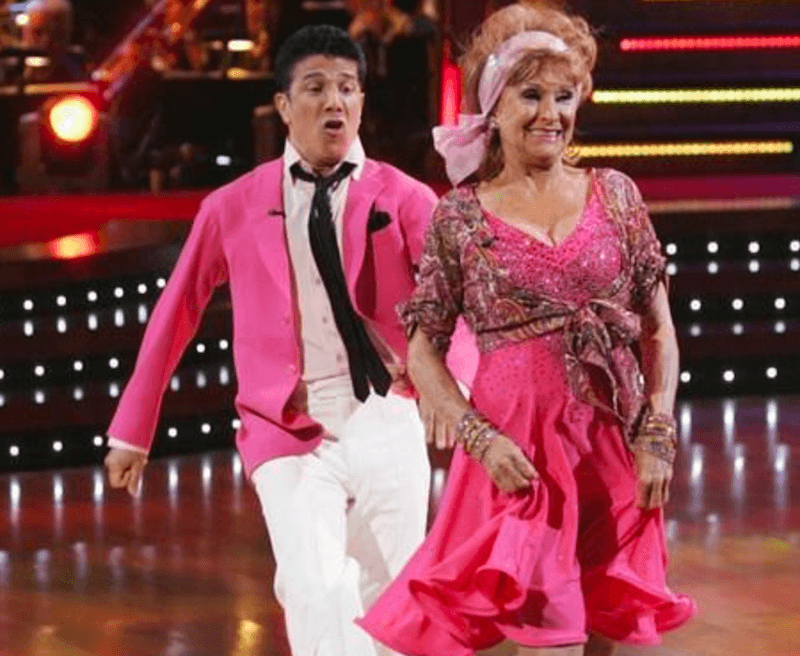 Cloris Leachman and Corky Ballas dancing while wearing pink outfits. Cloris Leachman and Corky Ballas dancing while wearing pink outfits.