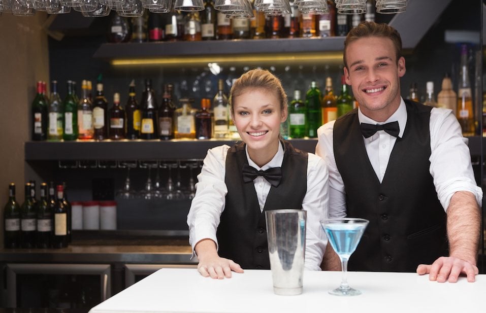 Colleagues smiling at the camera in a bar