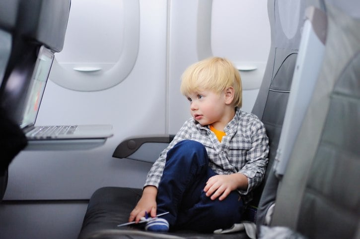 Cute little boy traveling by an airplane