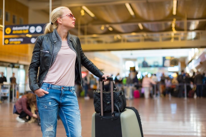 Female traveller checking flight departures board.
