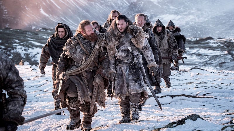 Jon Snow leads a pack of people through the snow mountains. 