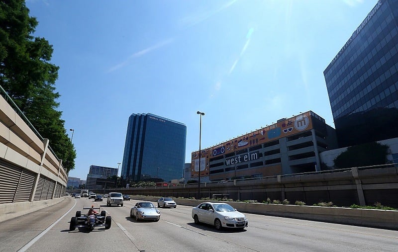 View of Ed Carpenter driving through DAllas in an Indy car in 2015.