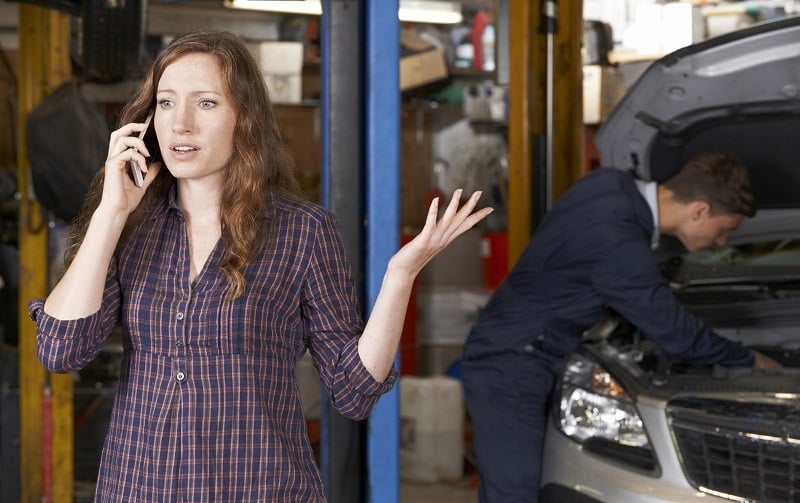 woman on phone at mechanic