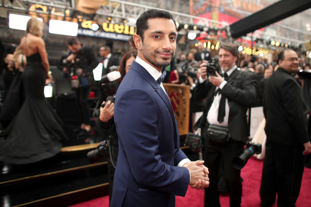 Riz Ahmed on the red carpet at the Oscars surrounded by cameras. Riz Ahmed on the red carpet at the Oscars surrounded by cameras.