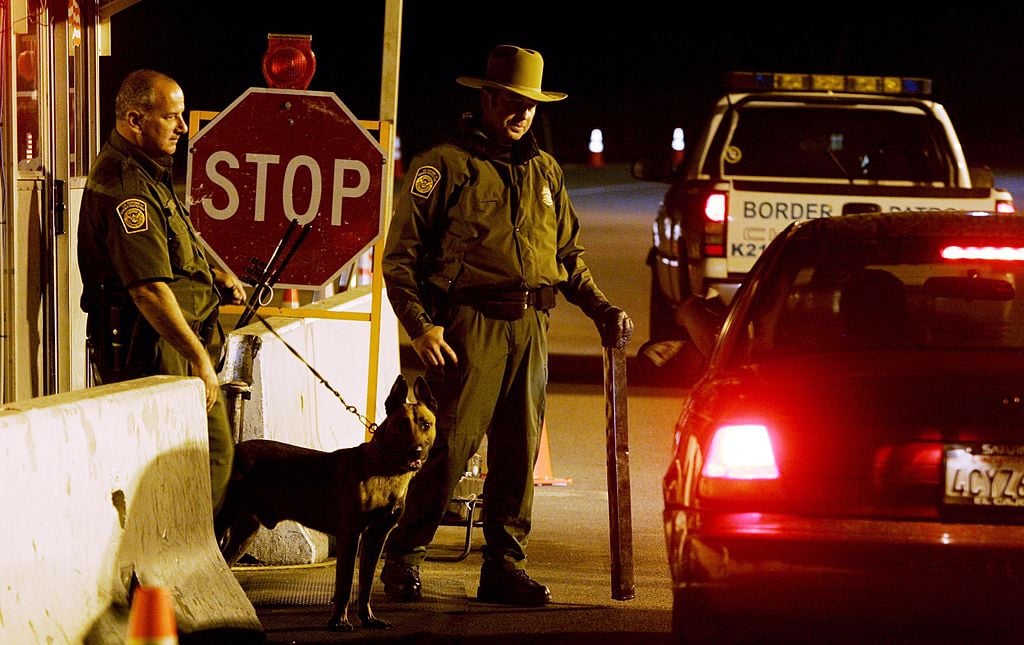 Customs and Border Patrol agents prepare to question a motorist at a checkpoint