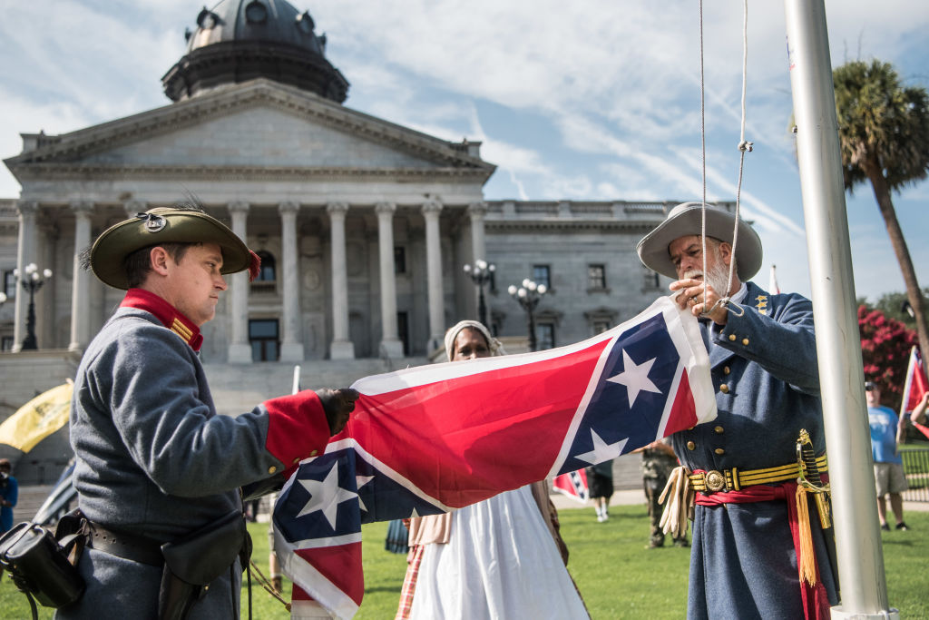 Two men raise a Confederate battle flag Two men raise a Confederate battle flag