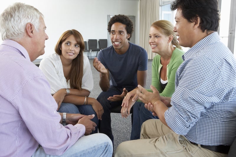 A support group sitting in a circle and talking A support group sitting in a circle and talking