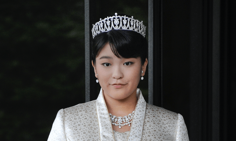 Princess Mako stands in a white suit and a crown. Princess Mako stands in a white suit and a crown.