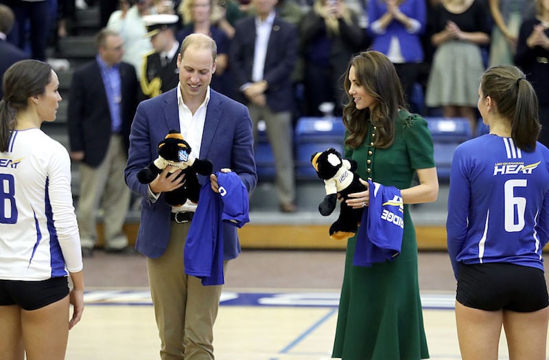 Prince William and Kate Middleton accept gifts at a basketball game.