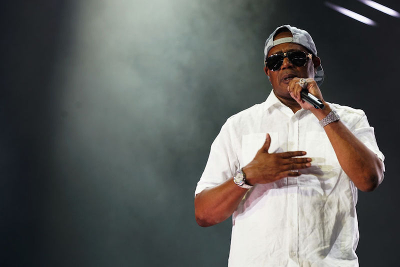 Master P holds a microphone while performing on stage.