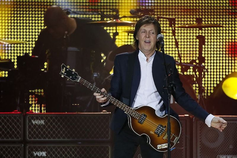 Paul McCartney playing his guitar and singing at a concert in France in 2015. Paul McCartney playing his guitar and singing at a concert in France in 2015.