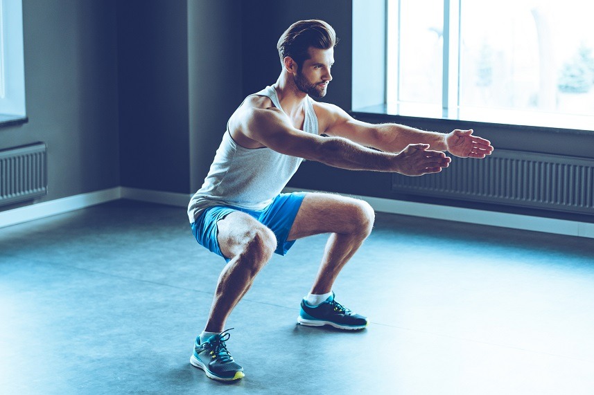 Man in sportswear doing squats at the gym Man in sportswear doing squats at the gym
