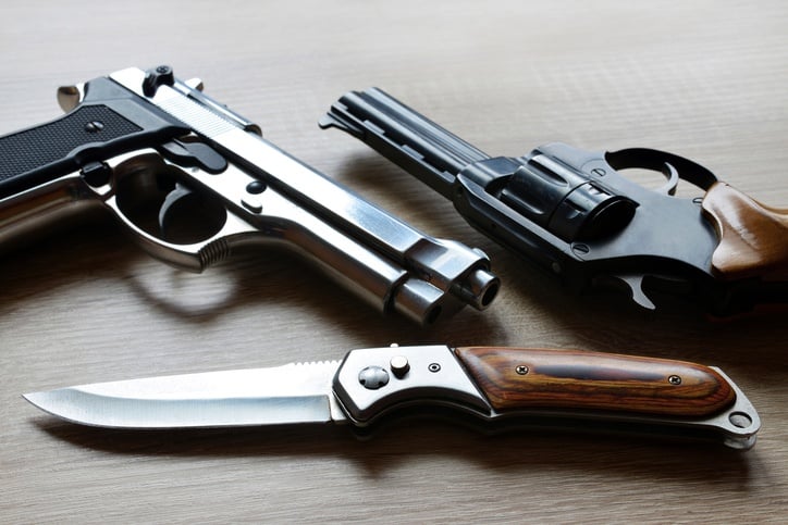 Pistols with knife on wooden board.