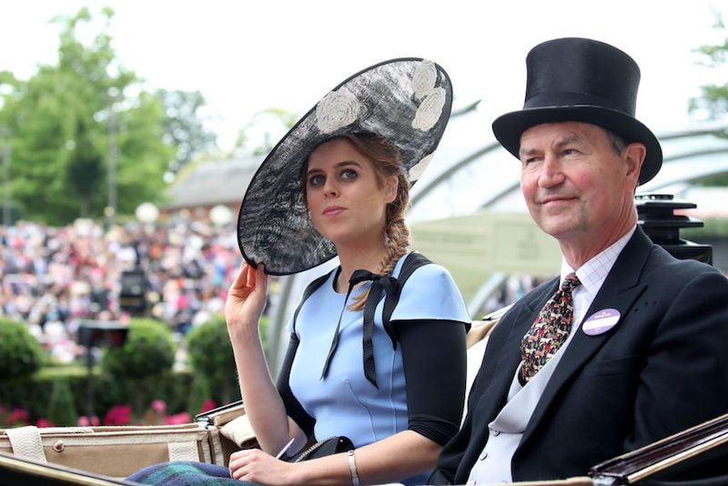 Princess Beatrice of York sits on a horse drawn carriage during a parade in London.