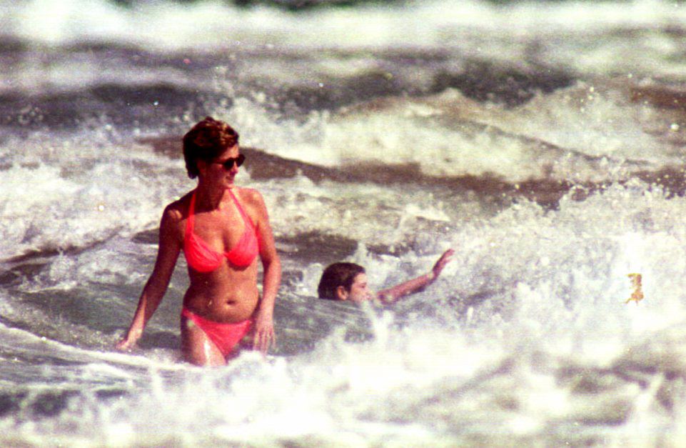 Princess Diana seen walking through some waves at the beach.