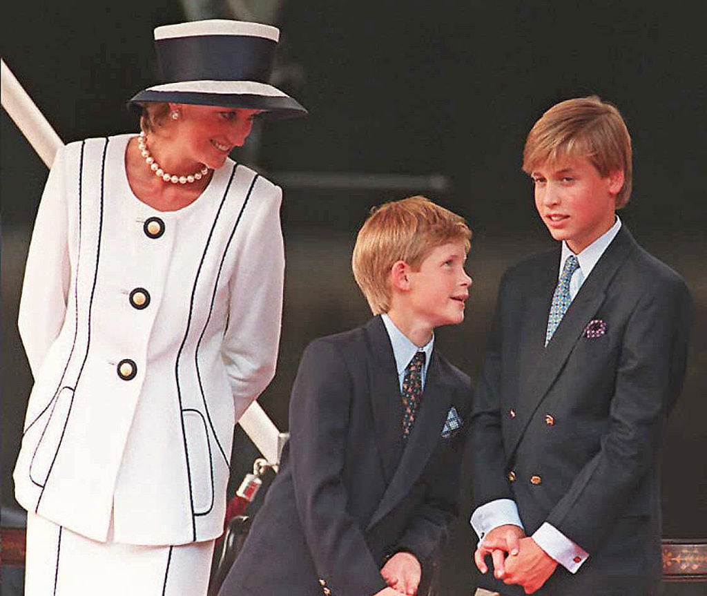 Princess Diana smiles as she watches Prince Harry and Prince William.