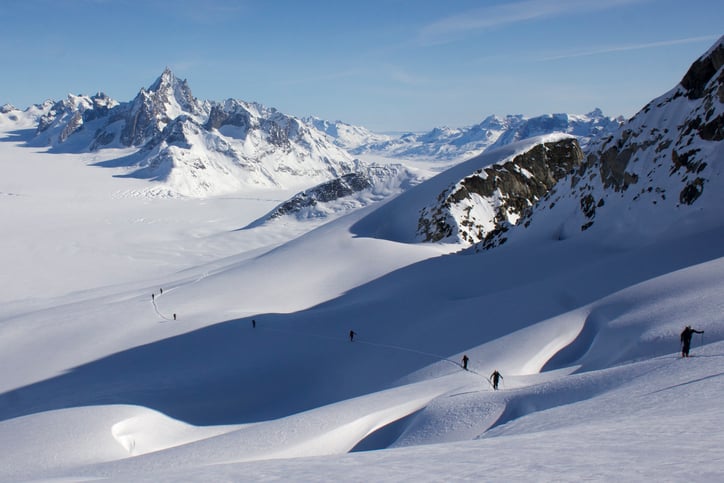 Ski climbing on a crevassed slope and infinite glacial scenery