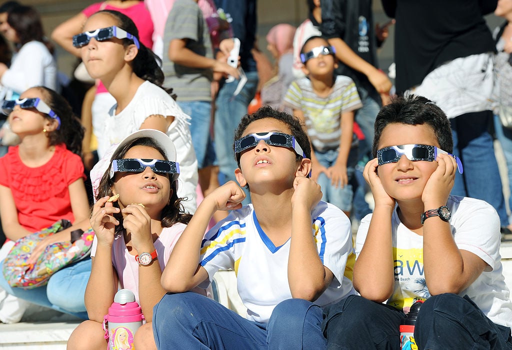 children watch the eclipse wearing glasses