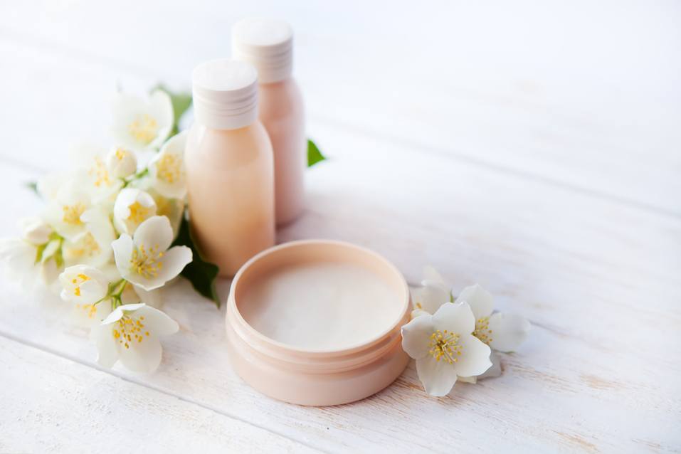 Spa setting with beauty cream and white jasmine flower