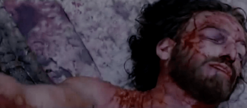 A bloodied man lays on the ground in The Passion of the Christ A bloodied man lays on the ground in The Passion of the Christ