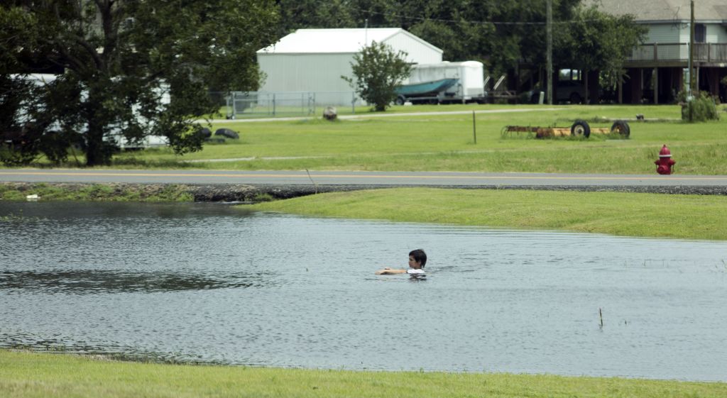 Boy swims in pond formed by storm