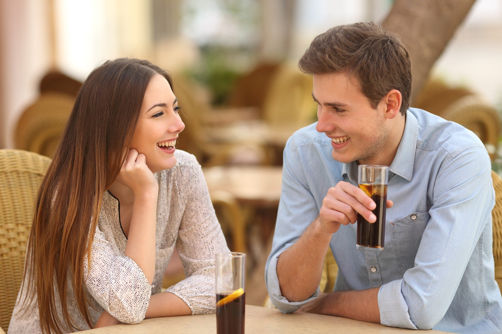 Happy couple talking in a restaurant and looking each other Happy couple talking in a restaurant and looking each other