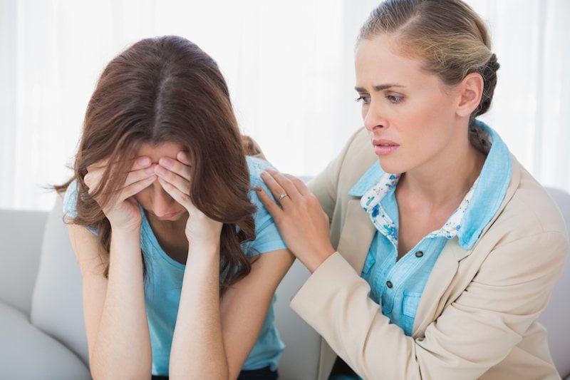 Crying woman with her concerned therapist