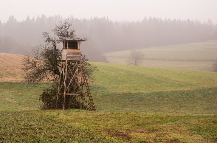 Wooden hunting lodge in the field