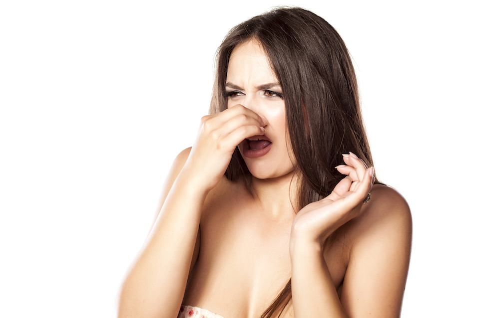 young girl closes her nose with her fingers