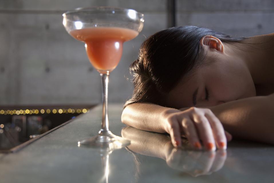 Young woman passed out on bar counter