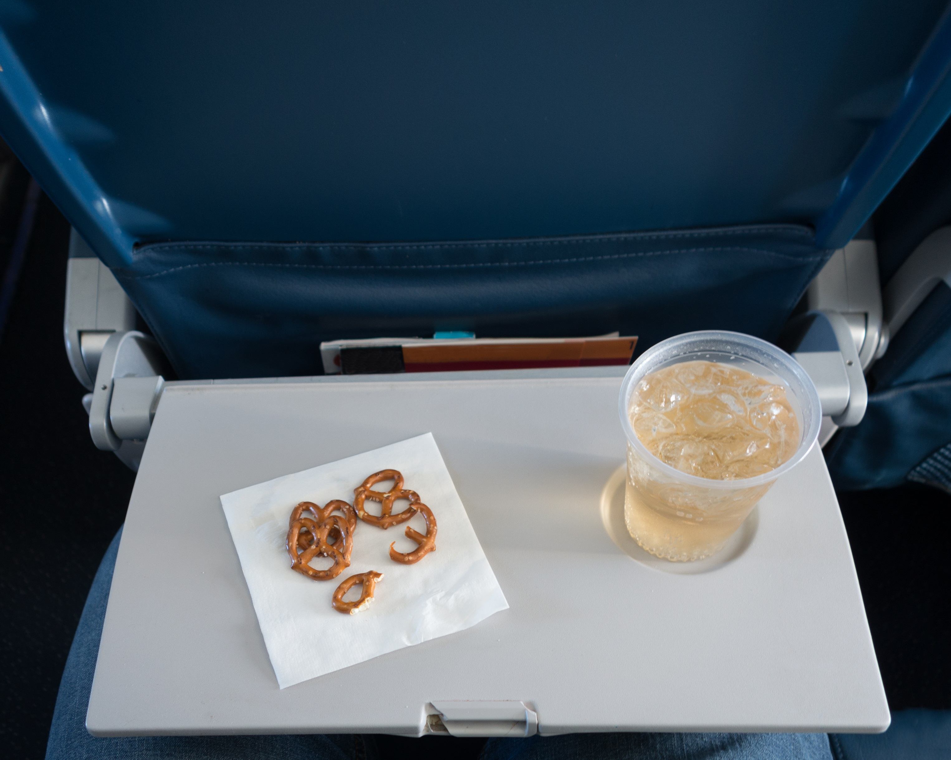 Tray table with pretzels and beverage