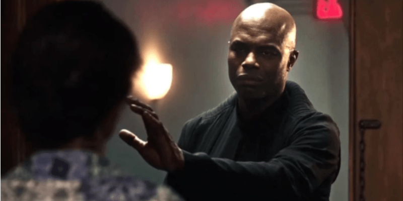 Chris Obi is dressed in all black and has one hand raised. Chris Obi is dressed in all black and has one hand raised.