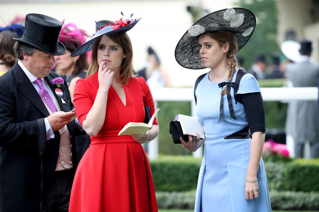 Princess Eugenie of York and Princess Beatrice of York stand while watching a parade.