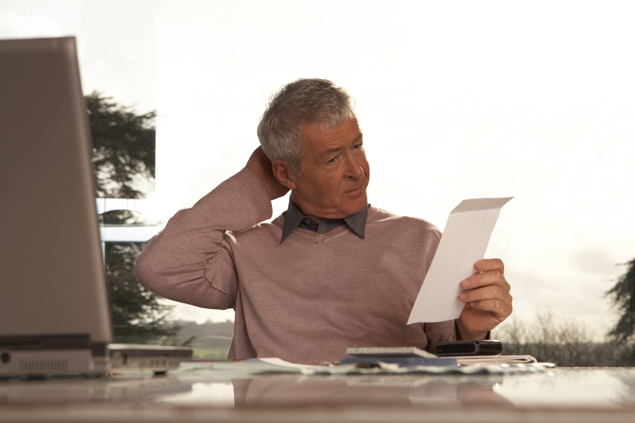 Confused older man at a desk