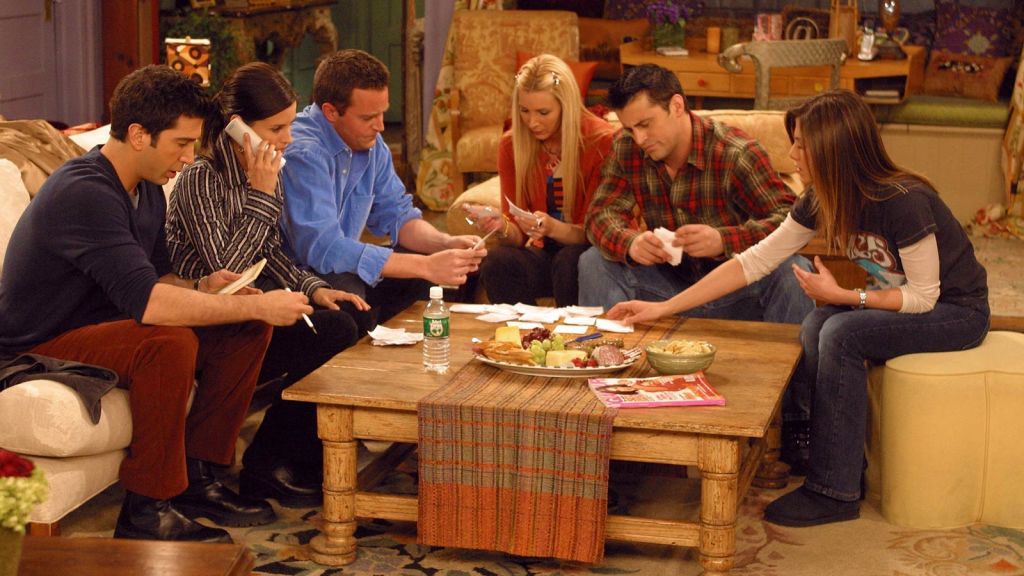 The 'Friends' gang hanging around wooden table in Monica's living room. 