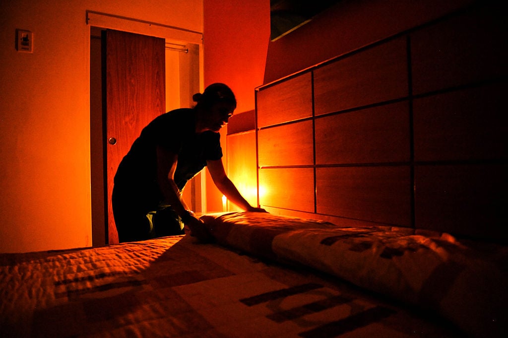 A chambermaid makes a bed at a hotel