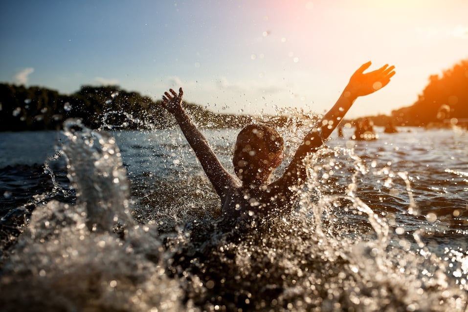 little kid play in water and making splas