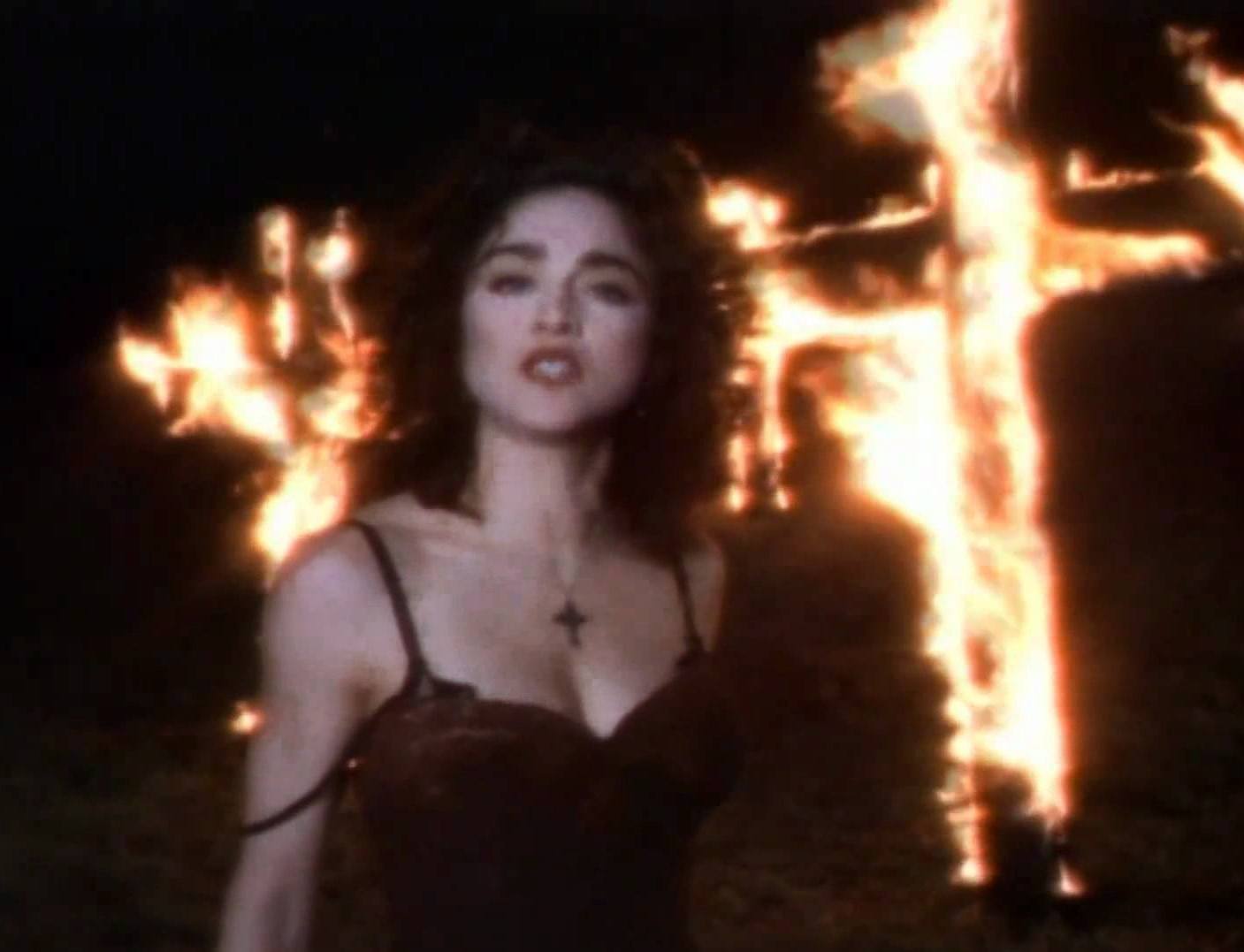 Madonna poses in front of a burning cross in her 'Like a Praye'r video. Madonna poses in front of a burning cross in her 'Like a Praye'r video.