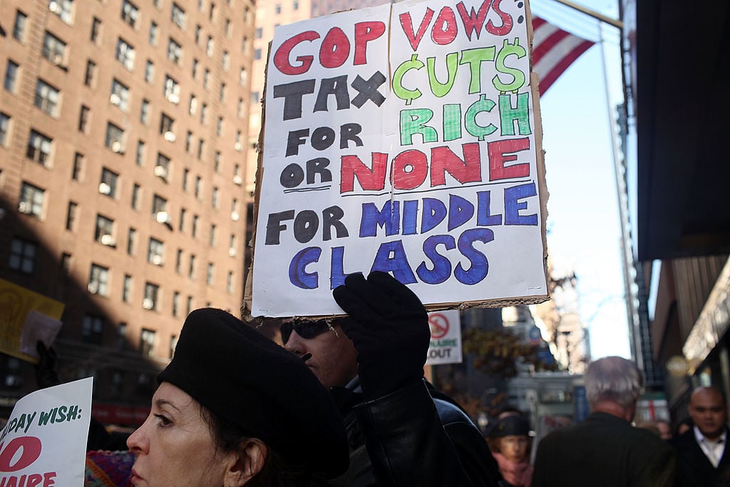 People attend a rally outside of the office of Sen. Charles Schumer (D-NY) to protest an extension of tax breaks for the wealthiest two percent of Americans